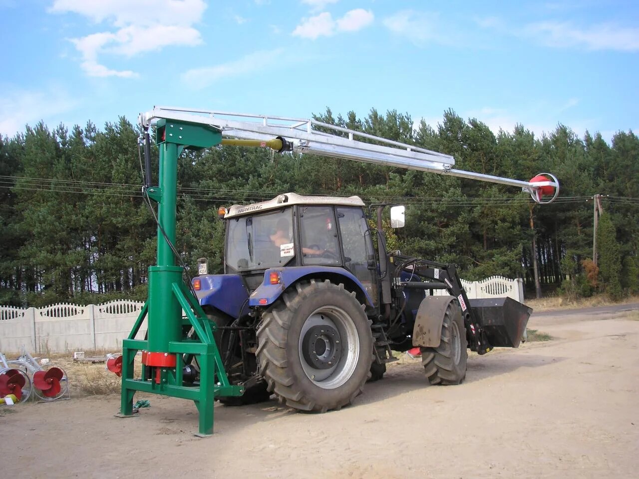 Gödselomrörare med vridbart stativ monterad bakom traktor.